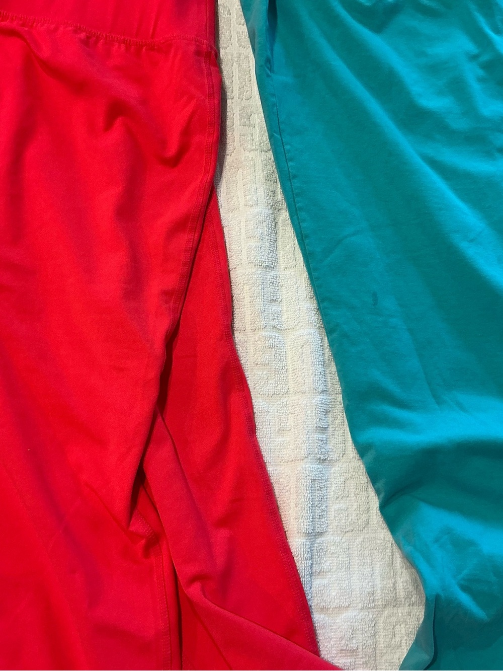 Two Livi Active adult Leggings in coral and teal color.
